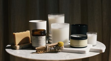 Home beauty products and candles sitting on a marble table in the sun Home beauty products and candles sitting on a marble table in the sun